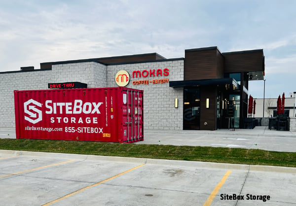 A SiteBox storage container sits outside a retail shop. 