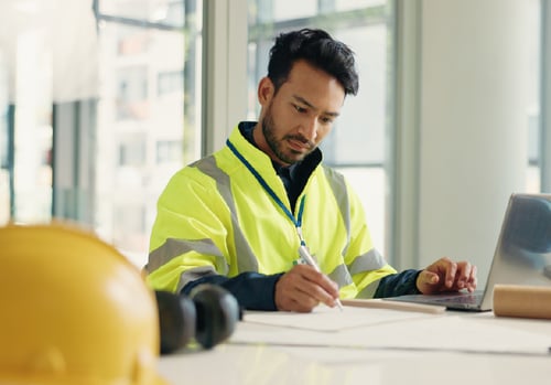 Contractor reviewing plans and researching portable storage container rentals for a construction project.